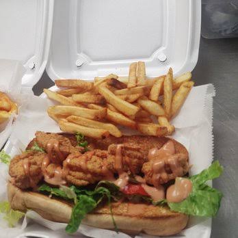 A dressed Who Dat po'boy with house sauce and a generous side of fries